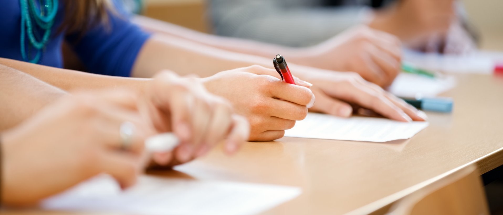 Schülerinnen und Schüler schreiben an Tischen während des Unterrichts