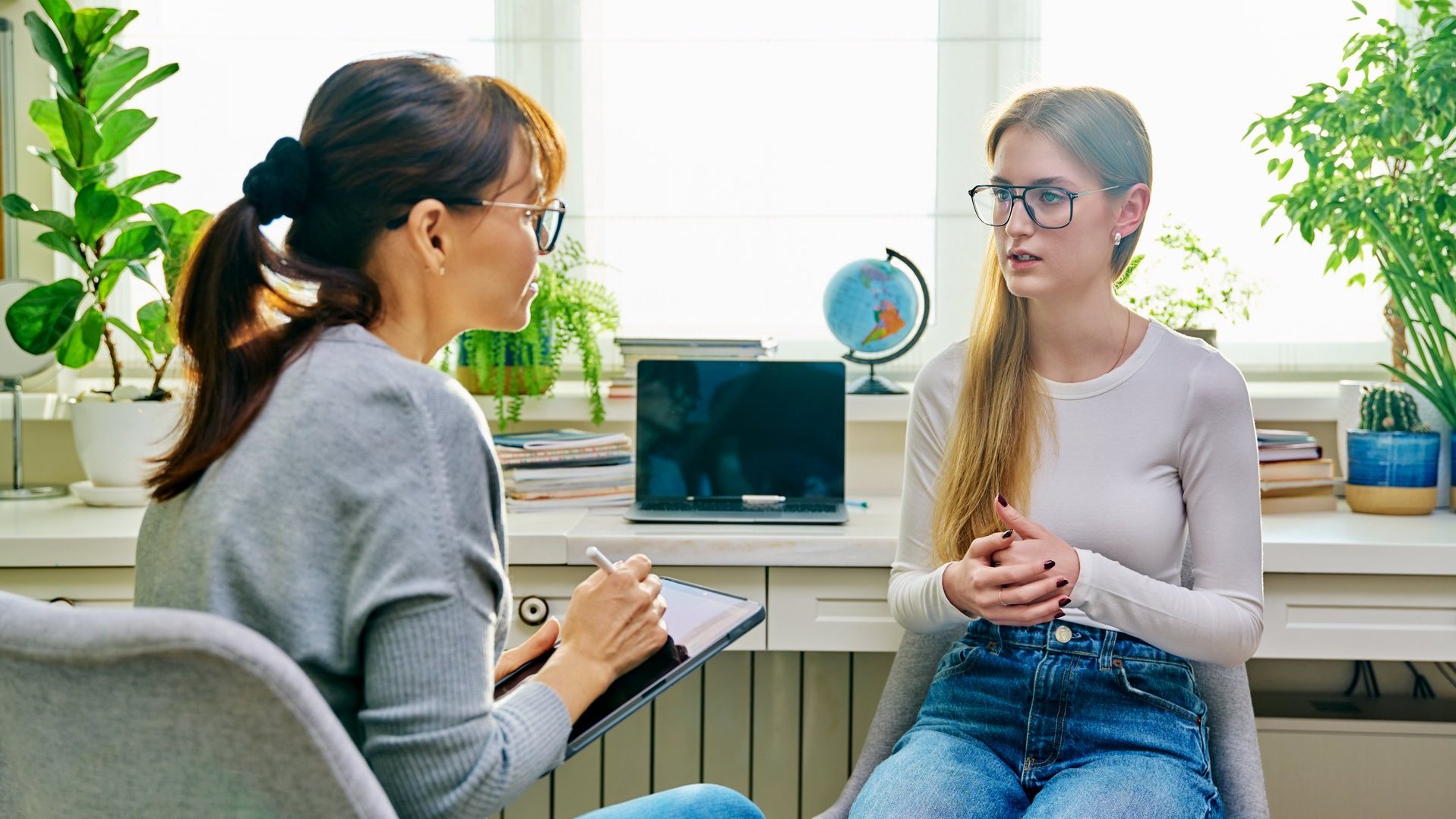 Zwei Frauen sitzen sich in einem Gespräch in einem Beratungsraum gegenüber