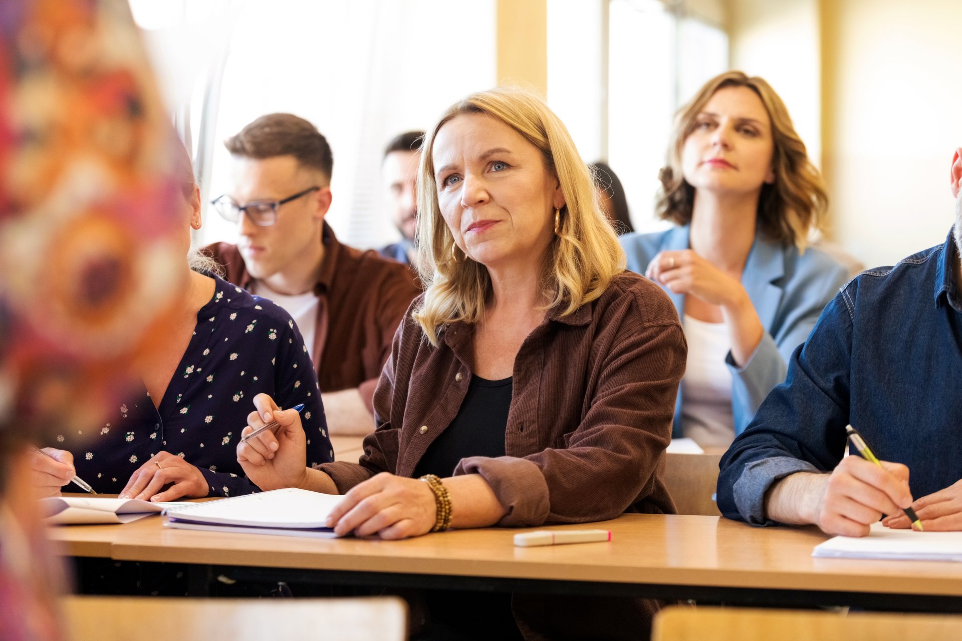 Teilnehmende sitzen aufmerksam in einer Schulung oder Vorlesung